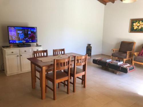 comedor con mesa, sillas y TV en LA CASITA en Tunuyán