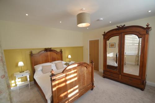 1 dormitorio con cama de madera y espejo grande en Charming 1 bed Georgian Apartment en Chester