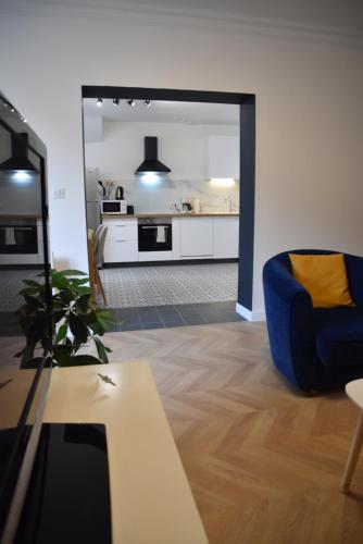 un salon avec une chaise bleue et une table dans l'établissement [Le 8] Maison de ville élégante et tout confort, à Saint-Martin-la-Rivière