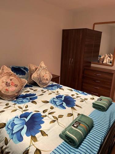 Una cama con flores azules y dos almohadas en 011- One bedroom in Ealing F3 en Ealing
