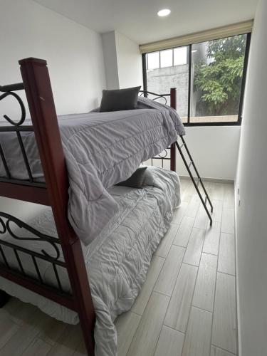 波哥大的住宿－Hermoso apartamento moderno, excelente ubicación cerca al centro histórico，一间卧室设有两张双层床和一扇窗户。