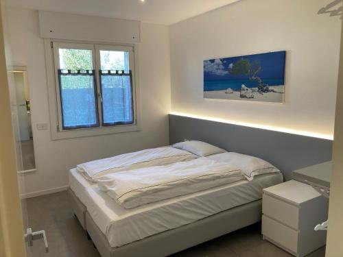 Un dormitorio con una cama y dos ventanas. en Casa Fiorella, en Nago-Torbole