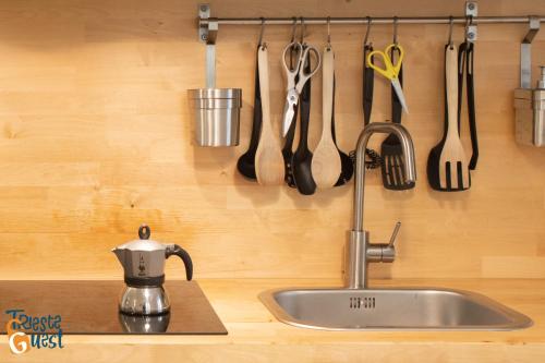 encimera de cocina con fregadero y utensilios en la pared en Casa Icarus, en Trieste