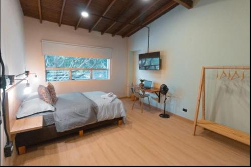 um quarto com uma cama e uma secretária. em NID201 Alquiler apartamento amoblado en Laureles em Medellín