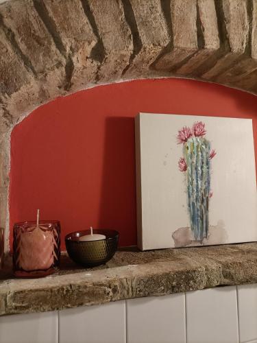 a painting of a cactus on a shelf with two candles at Domus Solarii Holiday Home in Bergamo