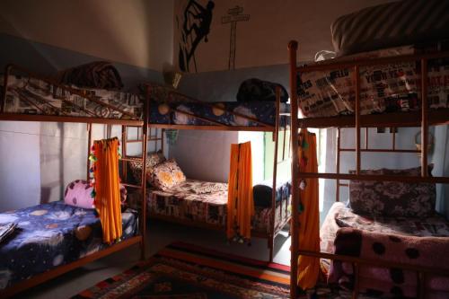 a room with three bunk beds and a window at Hike and Chill Homestay in Tinerhir