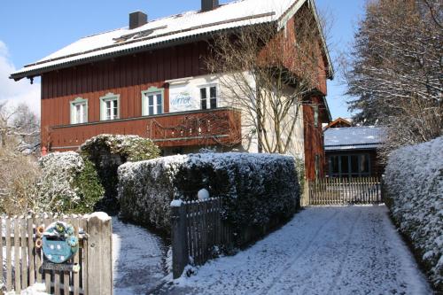 a house with a fence in the snow at Gästehaus Werner in Lenggries