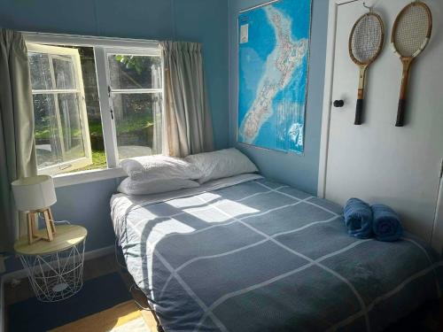 1 dormitorio con 1 cama y raquetas de tenis en la pared en Toad Hall, en Baylys Beach