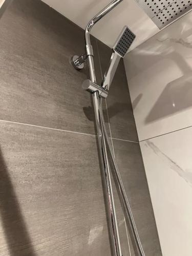 a shower nozzle in a bathroom with a tile floor at 009- Studio apartment in Ealing F5 in Ealing