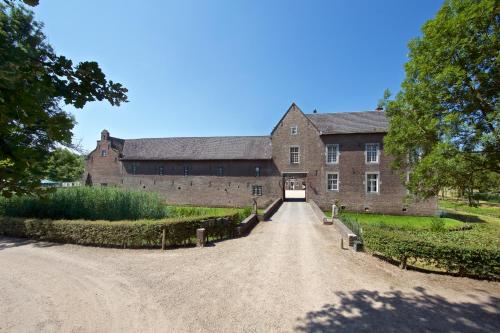 a large brick building with a dirt road in front at Terborgh Budget in Schinnen