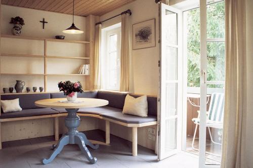 une chambre avec une table, un banc et une fenêtre dans l'établissement Gästehaus Werner, à Lenggries