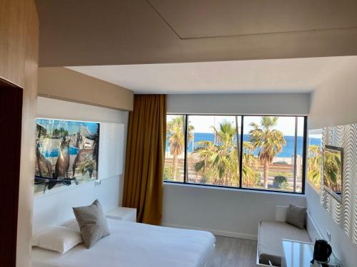 1 dormitorio con cama y vistas al océano en Marineland Hôtel en Antibes