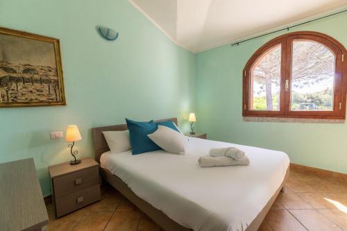 a bedroom with a large white bed with a window at Vista Mare Apartment 5 in Olbia