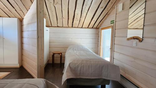 a bedroom with a bed in a wooden room at Loma-asunto Ahven, Kalajärvi, Maatilamatkailu Ilomäen mökit in Seinäjoki
