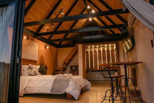 a bedroom with a bed in a room with wooden ceilings at Pousada das Pedras in Monte Verde