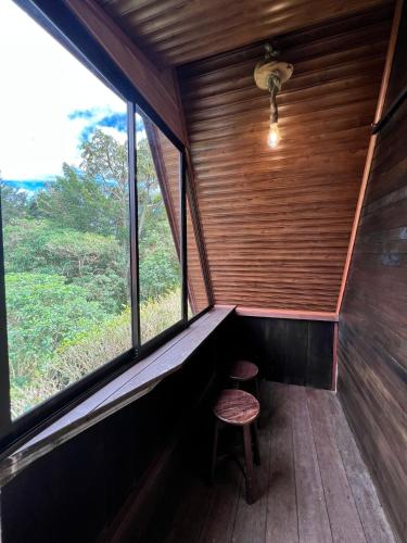 a room with a stool in a room with a window at Casa Tucan Glamping in Turrialba