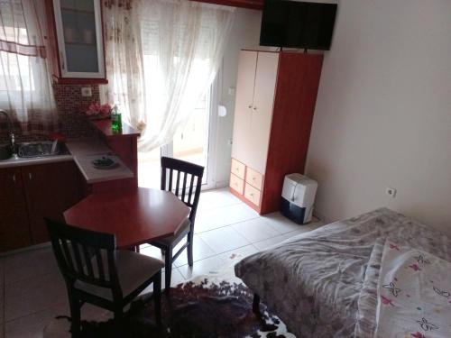 a kitchen and dining room with a table and a bed at Ιάνθη studio in Karditsa