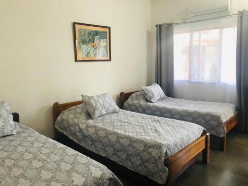 um quarto com duas camas e uma janela em Hotel Del Aserradero em Libéria