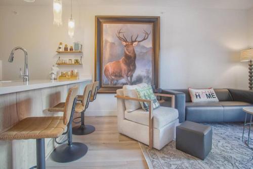 a living room with a deer painting on the wall at Cozy- Mountain Style - River View apartment - Colorado in Silverthorne