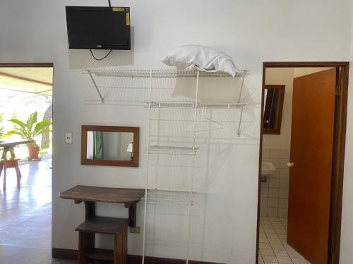 Habitación con mesa y TV en la pared. en Hotel Del Aserradero en Liberia