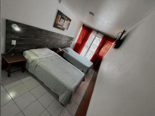 a small bedroom with a bed and a window at Hotel Plaza Colon in Arica