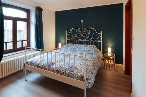 ein Schlafzimmer mit einem Bett und einer grünen Wand in der Unterkunft Nid'Ardennes in Bouillon