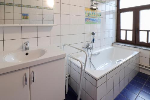 ein weißes Badezimmer mit einer Badewanne und einem Waschbecken in der Unterkunft Nid'Ardennes in Bouillon