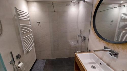 a bathroom with a shower and a sink and a mirror at Valentino Apartment in Castelrotto