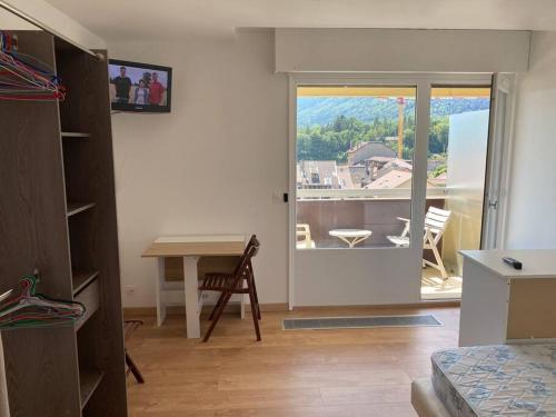 Pokój ze stołem i drzwiami na balkon w obiekcie HeberGeneve : Vue sur le Jura w mieście Gex