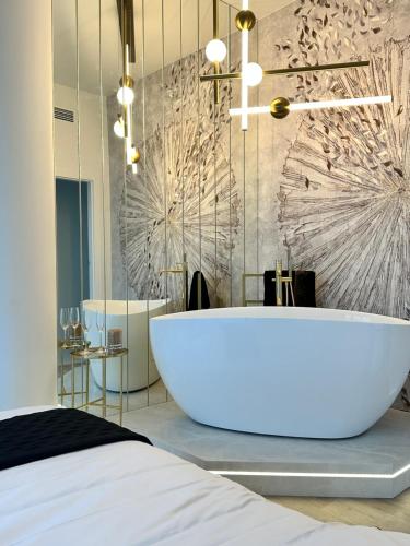 een badkamer met een groot wit bad in een kamer bij Apartament White Sky 20 Hanza Tower- Free parking in Szczecin