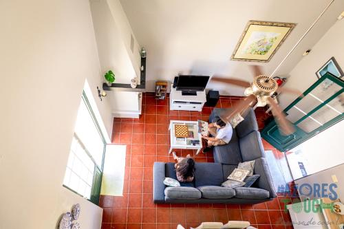 two people sitting on a couch in a living room at Porto Tranquilo in Porto Martins