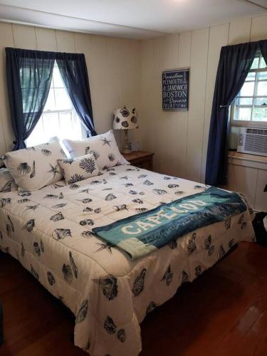 a bedroom with a bed with a football pillow on it at Scallop's Nest in Dennis Port