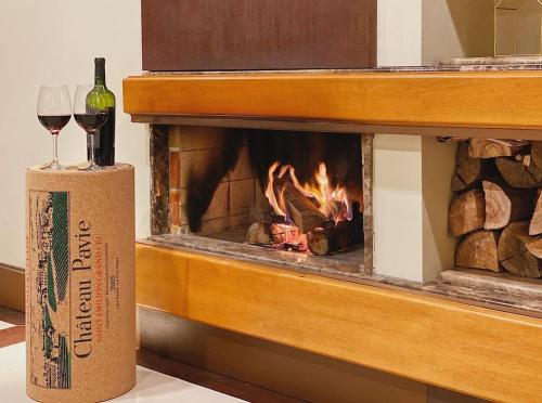 a bottle of wine sitting on a box next to a fireplace at Suíte Completa 3020 no Laje de Pedra Mountain Village Canela e Gramado Serra Gaúcha in Canela