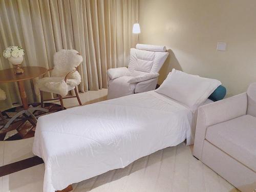 a hotel room with a bed and a chair and a table at Suíte Completa 3020 no Laje de Pedra Mountain Village Canela e Gramado Serra Gaúcha in Canela