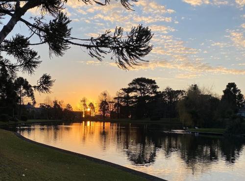 a view of a lake with the sunset in the background at Suíte Completa 3020 no Laje de Pedra Mountain Village Canela e Gramado Serra Gaúcha in Canela