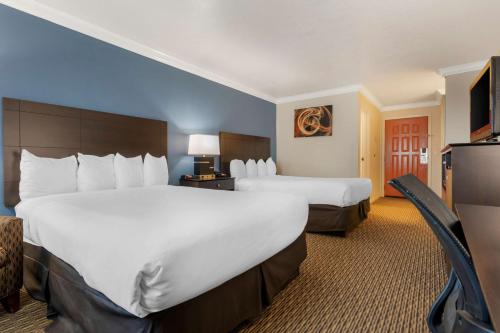 ein Hotelzimmer mit 2 Betten und einem TV in der Unterkunft Best Western Colonial Inn in Selma
