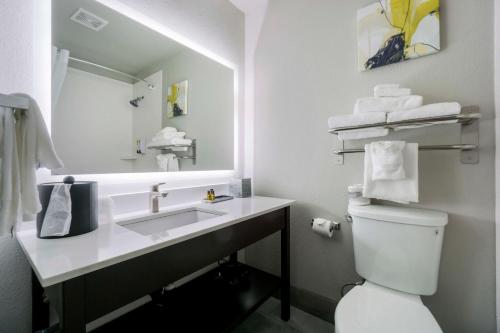 uma casa de banho com um lavatório, um WC e um espelho. em Best Western Plus Renton Inn em Renton