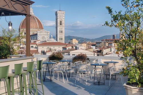 a patio with tables and chairs and a view of a city at NH Collection Palazzo Gaddi in Florence