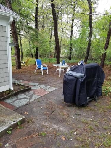 a backyard with a table and chairs and a tent at Scallop's Nest in Dennis Port