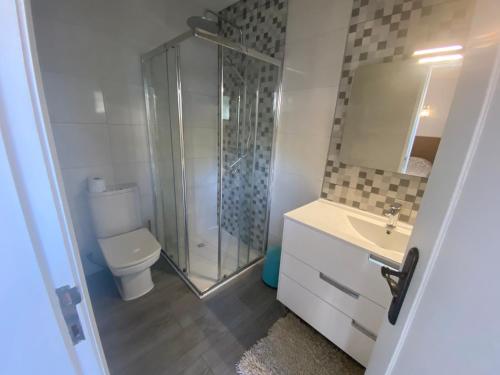 アルブフェイラにあるMoradia muito acolhedoraのバスルーム(シャワー、トイレ、シンク付)