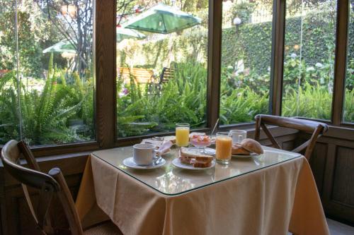 een tafel met ontbijtproducten en sinaasappelsap erop bij Hotel Casagrande in Arequipa