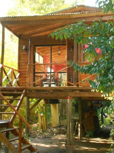 a small wooden cabin with a porch and a deck at Cabaña Los Alcanfores in Tigre