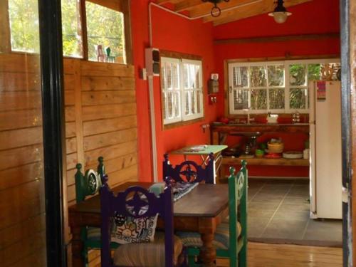 a dining room with a table and a kitchen at Cabaña Los Alcanfores in Tigre