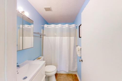 y baño con aseo blanco y lavamanos. en Wendwood Condominiums F2 en Panama City Beach