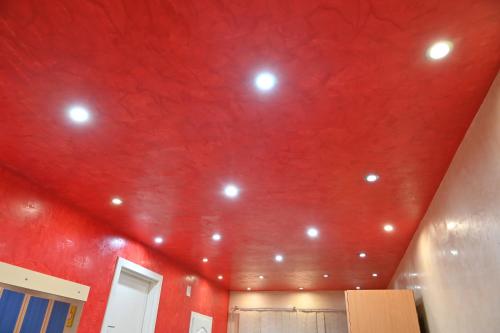 a room with a red ceiling with lights on it at Apartmani Tomašević in Paraćin
