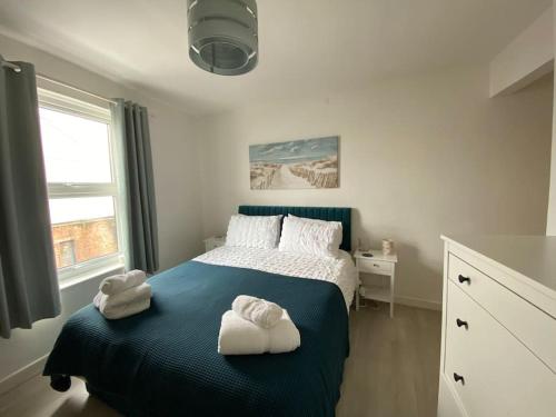 a bedroom with a bed with two towels on it at Cowes Cottage in Cowes