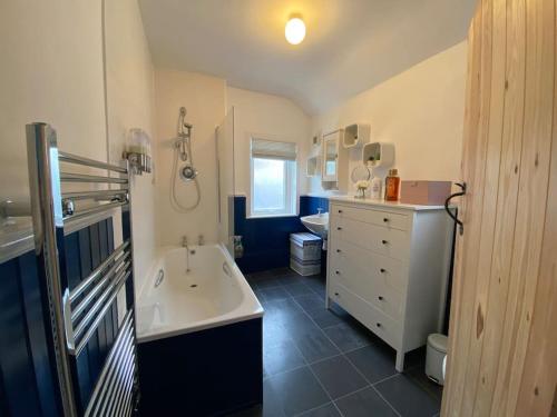 uma casa de banho com uma banheira, um lavatório e um WC. em Cowes Cottage em Cowes