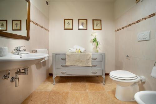 a white bathroom with a sink and a toilet at Domus Antiqua Bed & Breakfast in Spello