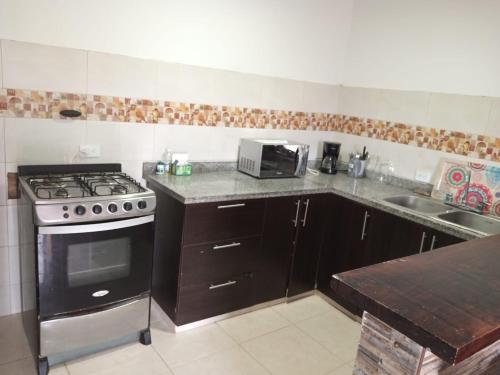 a kitchen with a stove and a sink at Casa Maral Hostal in Salento