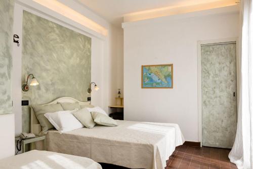 a bedroom with two beds and a painting on the wall at Hotel Marina in Monterosso al Mare